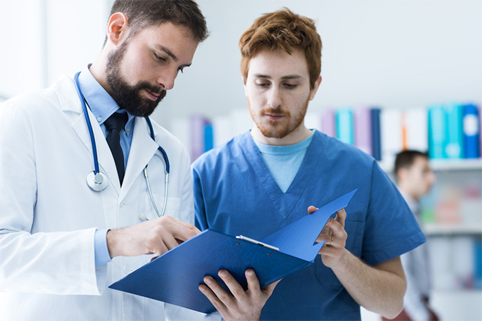 male doctor and medical assistant checking paperwork