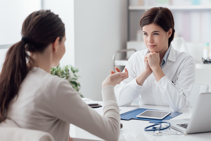 doctor listening to patient in office