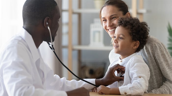 nurse practitioner examining young patient with stethoscope