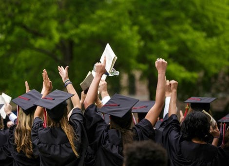 Medical school graduates celebrating in cap and gown at graduation ceremony