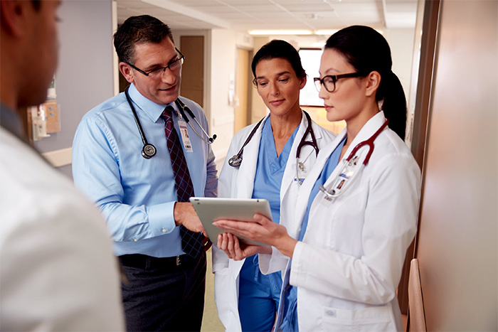 doctors wearing stethoscopes looking at information