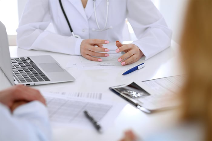 nurse in white lab coat talking with patients