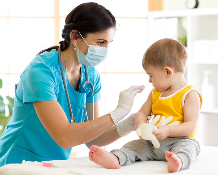 pediatric doctor preparing baby for vaccination