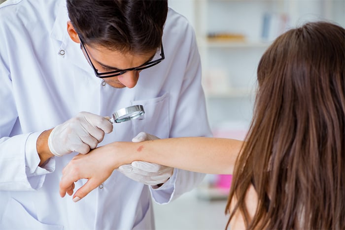 dermatologist examining patient skin