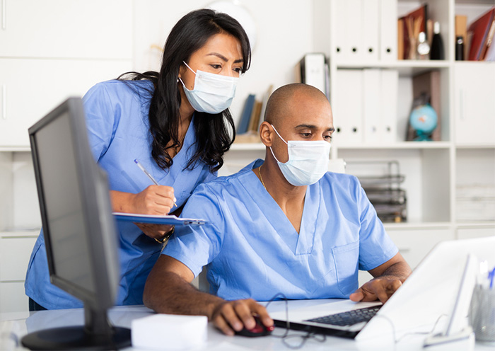 doctor and nurse checking data on computer