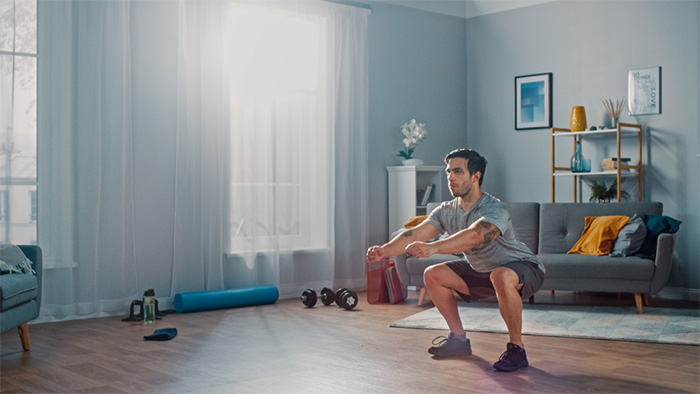 man doing squats at home