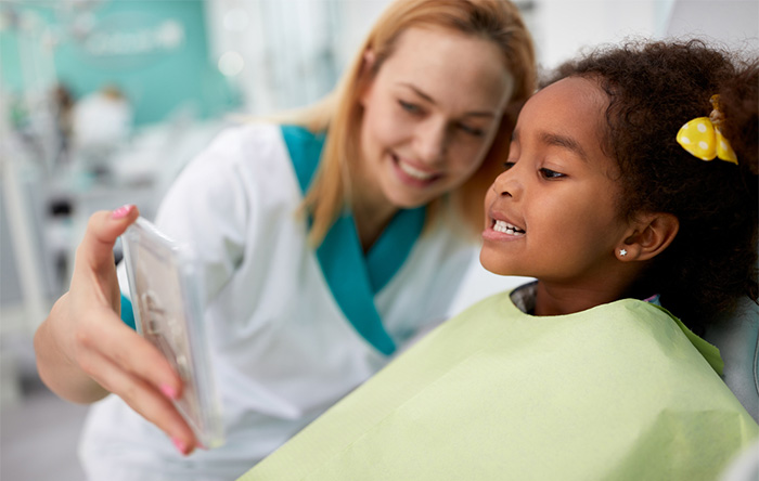 young patient showing dental assistant their teeth