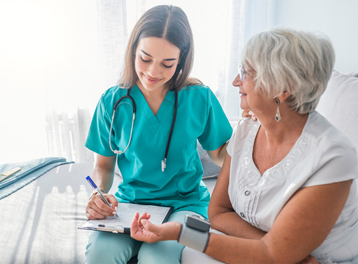 nurse measuring blood pressure for senior woman