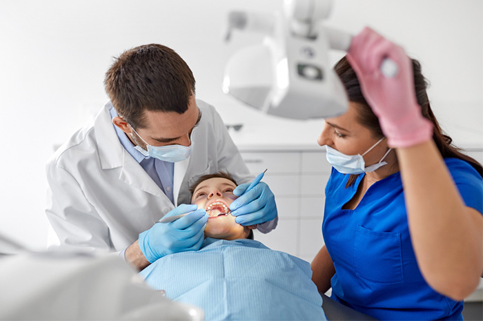 dentist and dental assistant examining patient