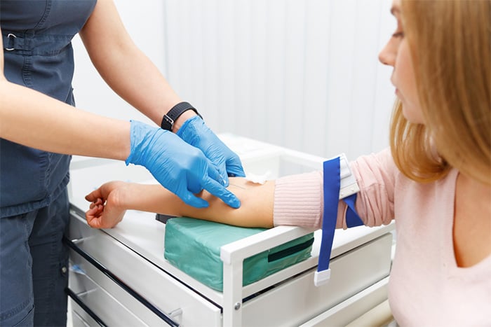 medical assistant drawing blood from patient