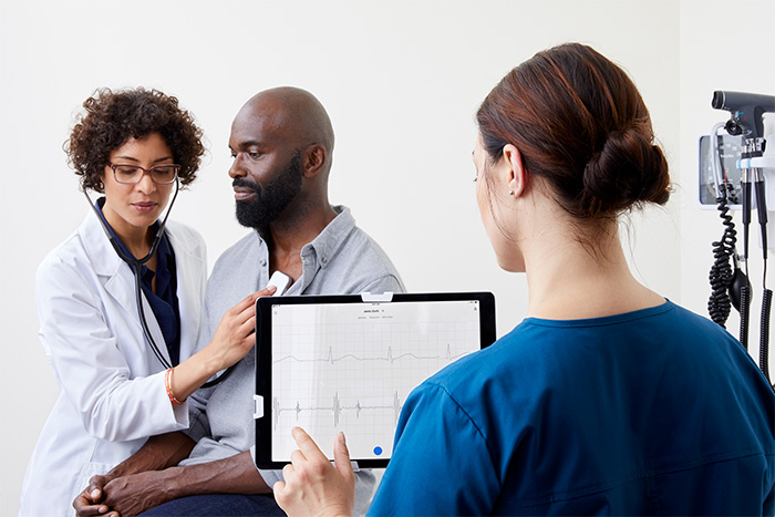 clinician using eko duo stethoscope with earpiece on male patient