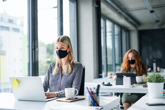 young female professionals wearing face masks at work