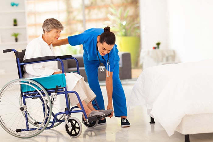 caergiver helping elderly woman in a wheelchair