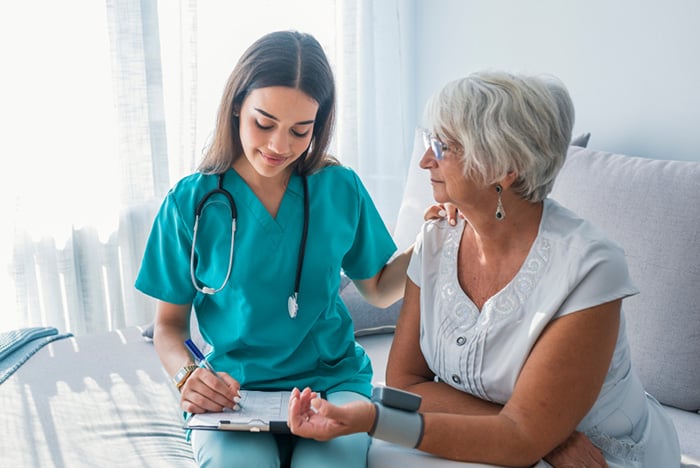 young nurse monitoring patient blood pressure