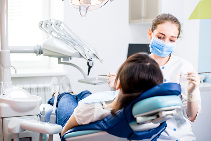 girl laying down while dental hygienist treats teeth