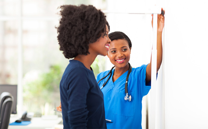 medical assistant measuring patient height