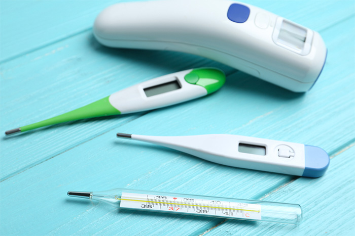 different types of thermometers on blue wooden surface 