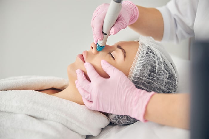 esthetician performing beauty treatment on client