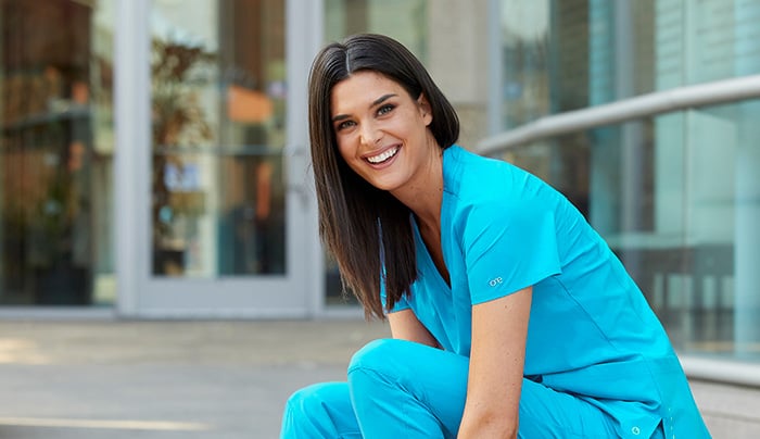 smiling nurse wearing blue lightweight scrubs
