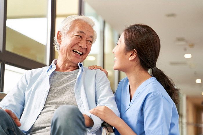 young female caregiver laughing with patient