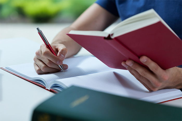 student reading and taking notes in book