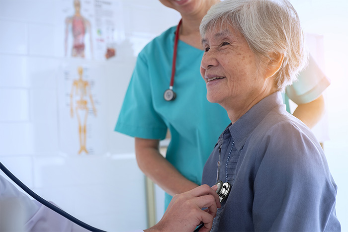 doctor using stethoscope on elderly patient