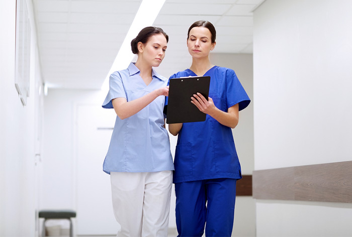 nurse and medical assistant discussing paperwork